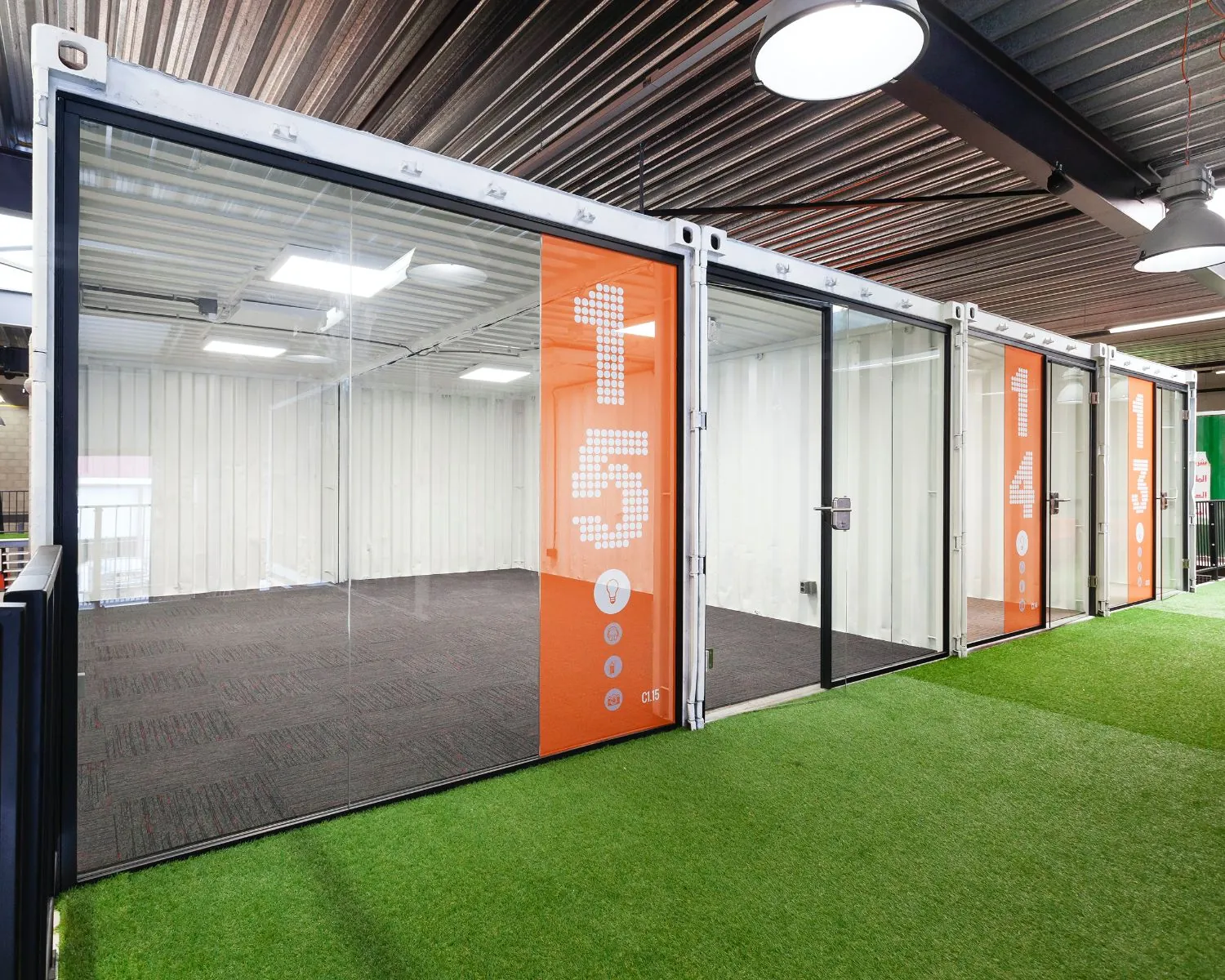 Moderne kantoorruimte in unit 15 van Hoofdveste 2 in Houten met glazen wanden en kunstgrasvloer buiten de ruimte.