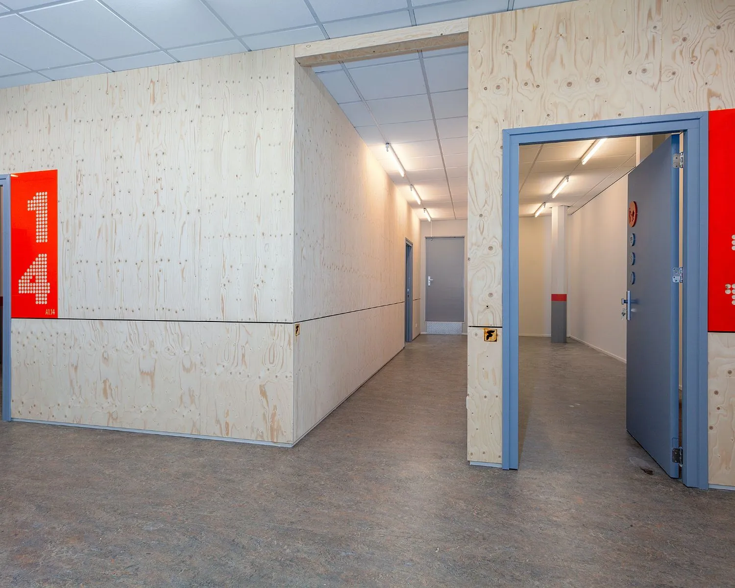 Moderne kantoorruimte met lichte houten wanden en grijze deuren aan de Innsbruckweg 130 in Rotterdam.