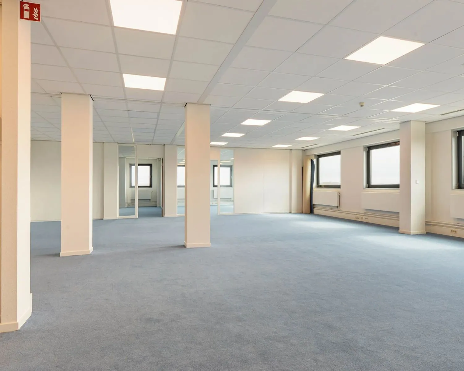 Licht en ruim kantoorinterieur met blauwe vloerbedekking aan de Joan Muyskenweg 40-146 in Amsterdam.