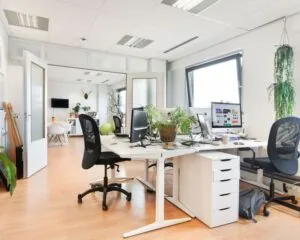 Moderne, lichte kantoorruimte met werkplekken en planten aan de Joan Muyskenweg 40 in Amsterdam.