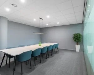 Moderne vergaderruimte met lange tafel en blauwgrijze stoelen in Kennedy Tower in Eindhoven.