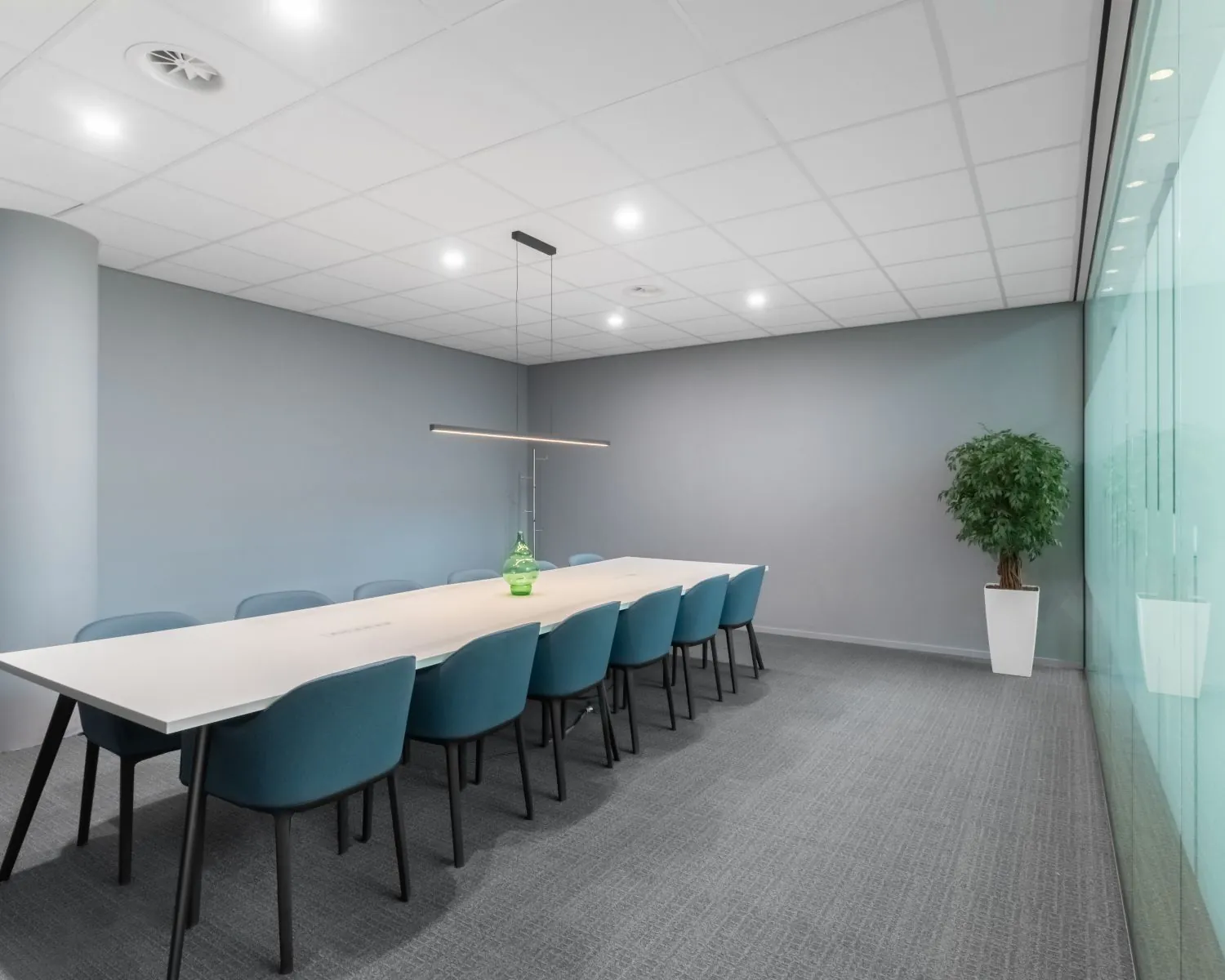 Moderne vergaderruimte met lange tafel en blauwgrijze stoelen in Kennedy Tower in Eindhoven.