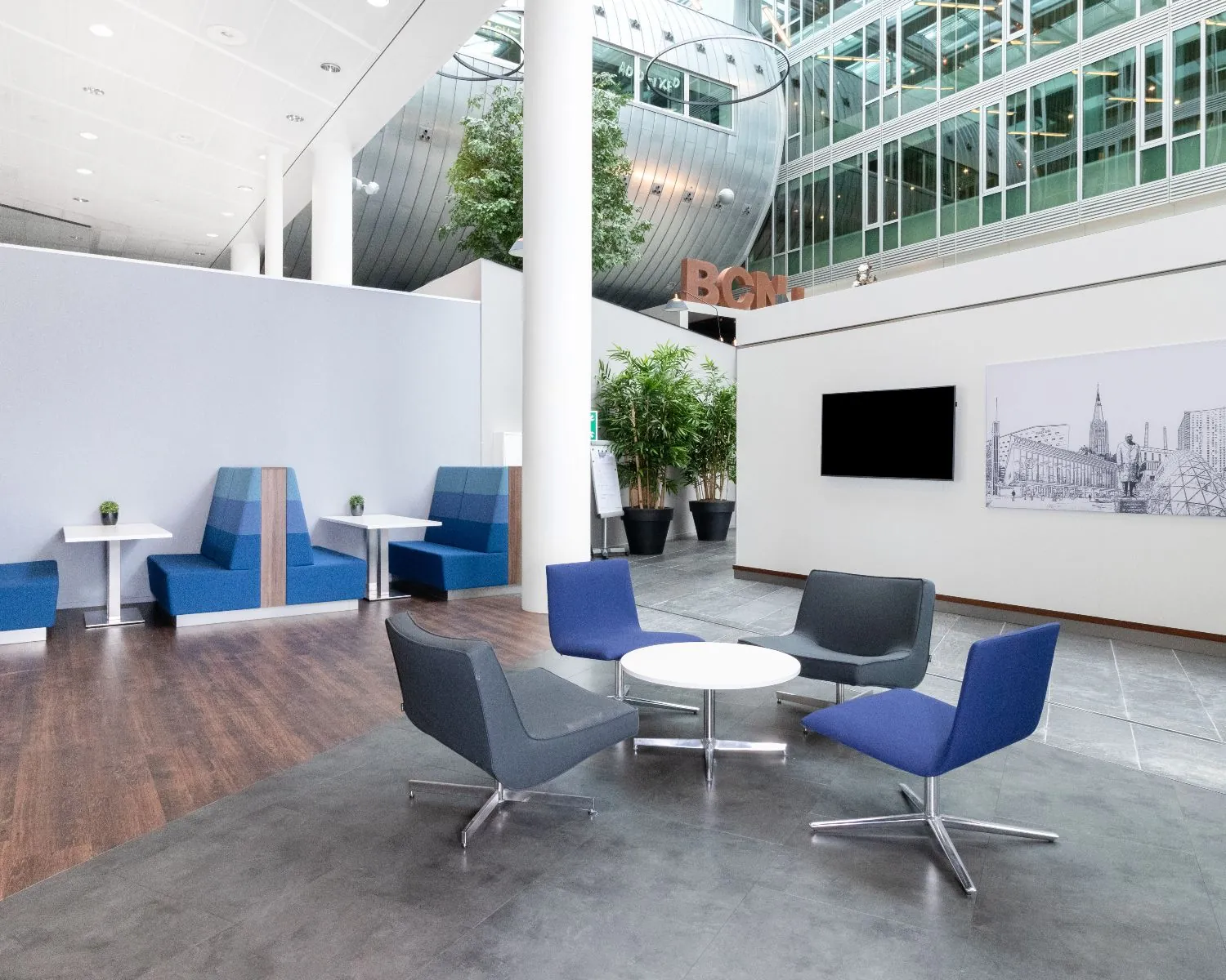 Moderne kantoorlobby in Kennedy Tower Eindhoven met zitgedeelte en blauwe stoelen.