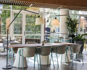 Moderne kantoorruimte aan de PJ Oudweg 41 in Almere met een grote houten vergadertafel, designstoelen en veel natuurlijk licht.