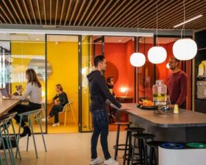 Moderne kantoorruimte aan de PJ Oudweg 41 in Almere met een gezamenlijke keuken en kleurrijke vergaderruimtes.