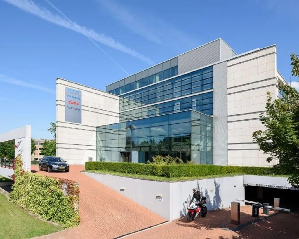 Modern kantoorgebouw aan de Polarisavenue met glazen entree, oprit en ondergrondse parkeergarage.