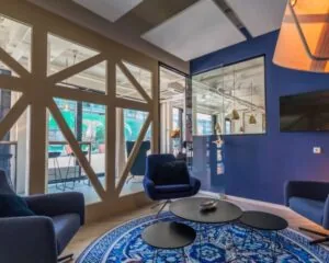 Moderne loungeruimte in kantoor aan de Roggestraat 111 in Apeldoorn met blauwe muren, glazen wanden en stijlvolle meubels.