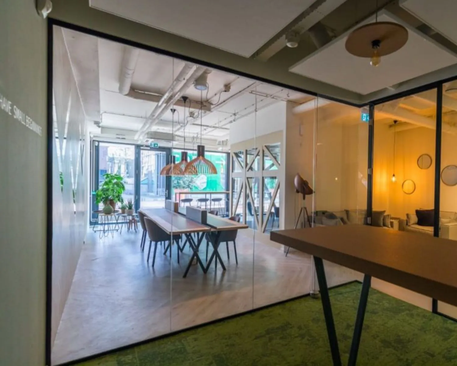 Moderne kantoorruimte met glazen wanden, lange werktafel en zithoek aan de Roggestraat 111 in Apeldoorn.