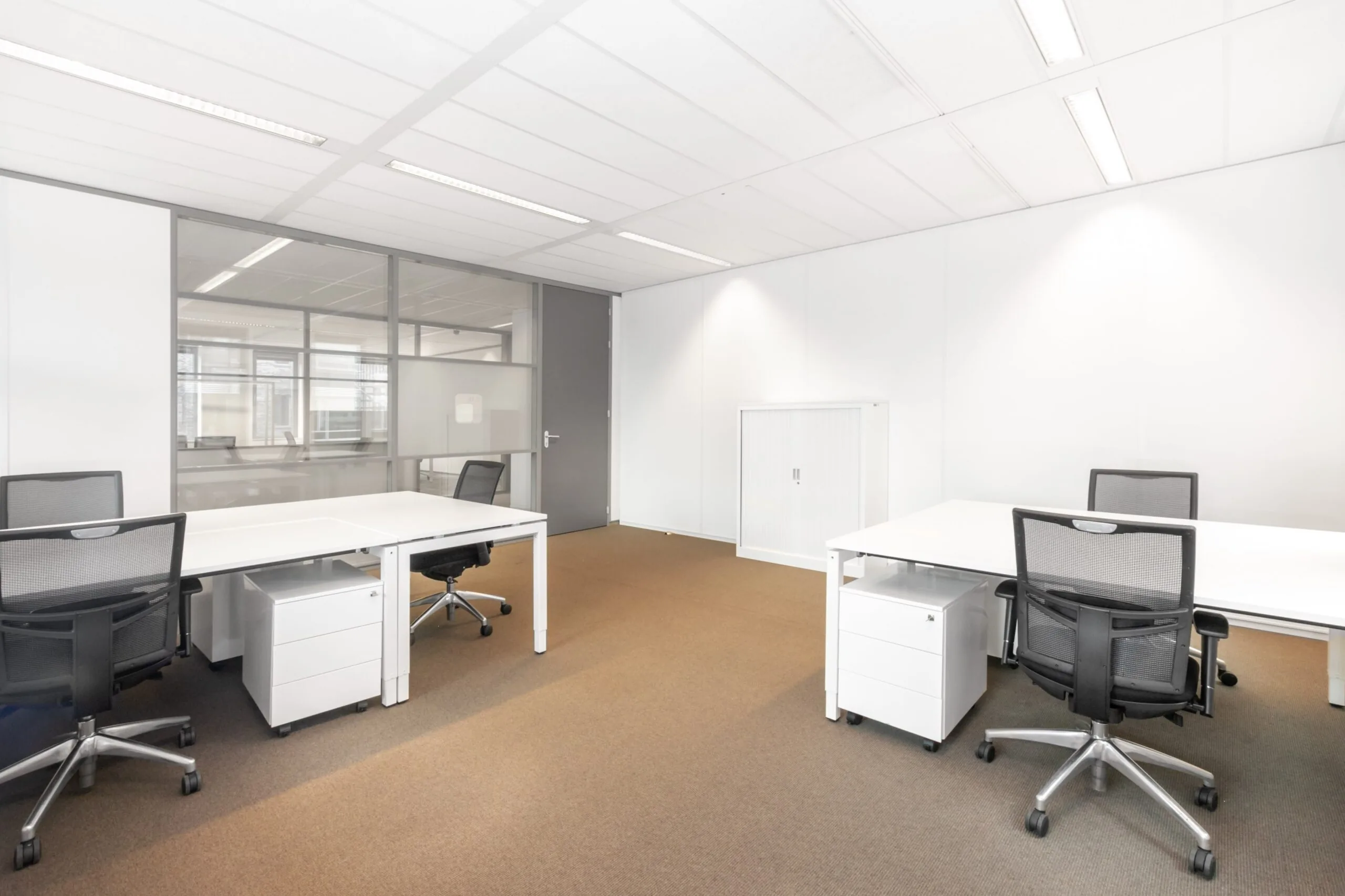 Moderne, lichte kantoorruimte met vier bureaus en bureaustoelen aan het Smallepad 32 in Amersfoort.