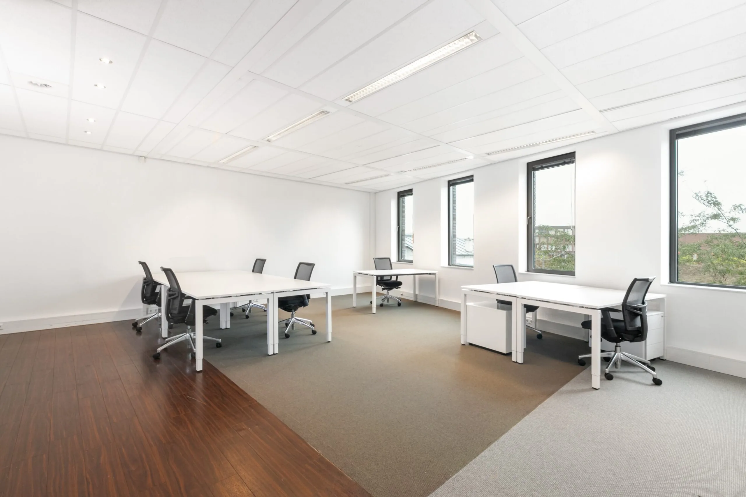 Moderne, lichte kantoorruimte met meerdere bureaus en bureaustoelen aan het Smallepad 32 in Amersfoort.