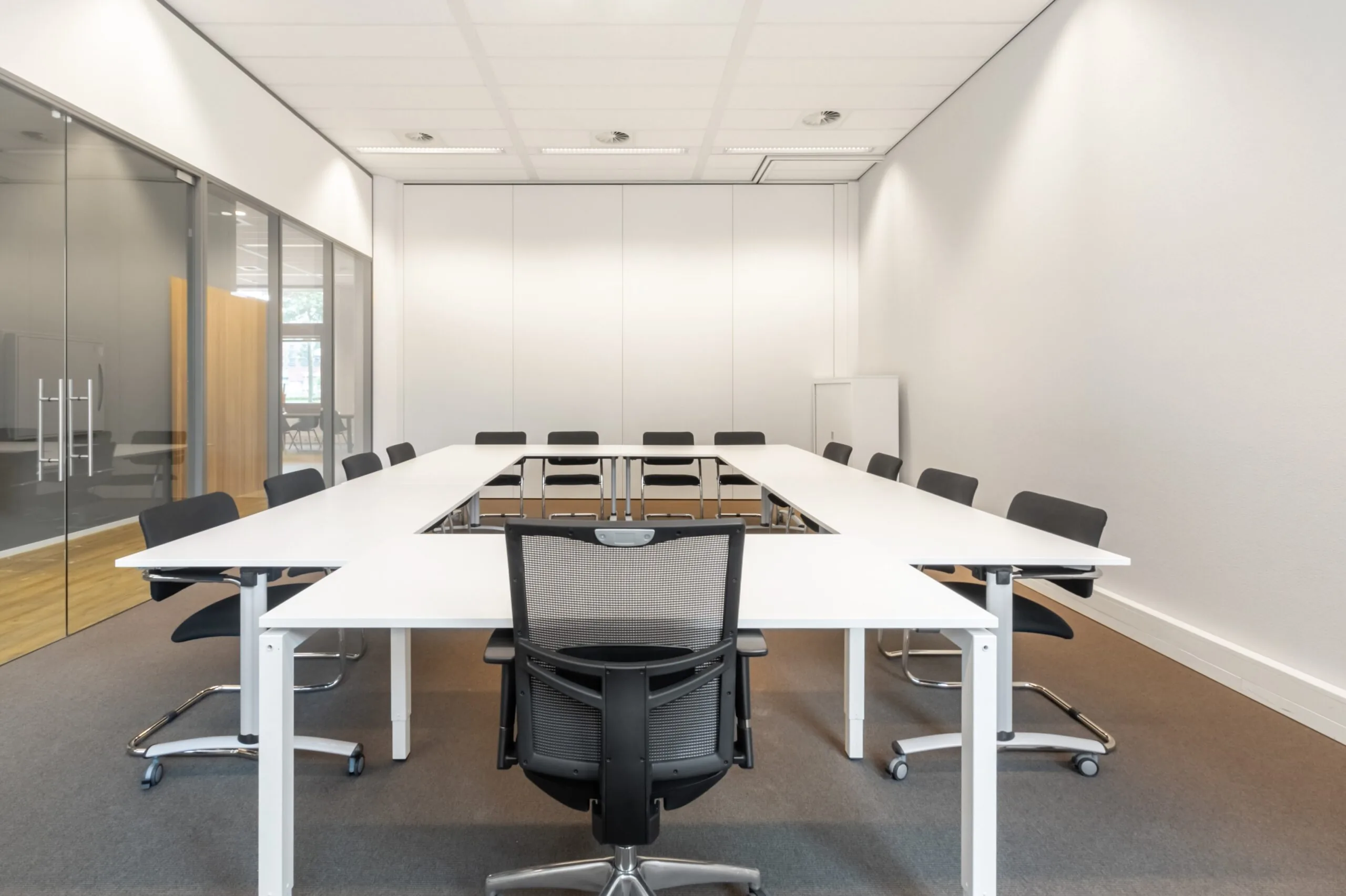 Moderne vergaderruimte met U-opstelling en zwarte stoelen in kantoorpand aan het Smallepad 32 in Amersfoort.