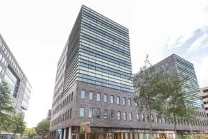 Modern kantoorgebouw aan het Smallepad 32 in Amersfoort met grote glaspartijen en bakstenen gevel.