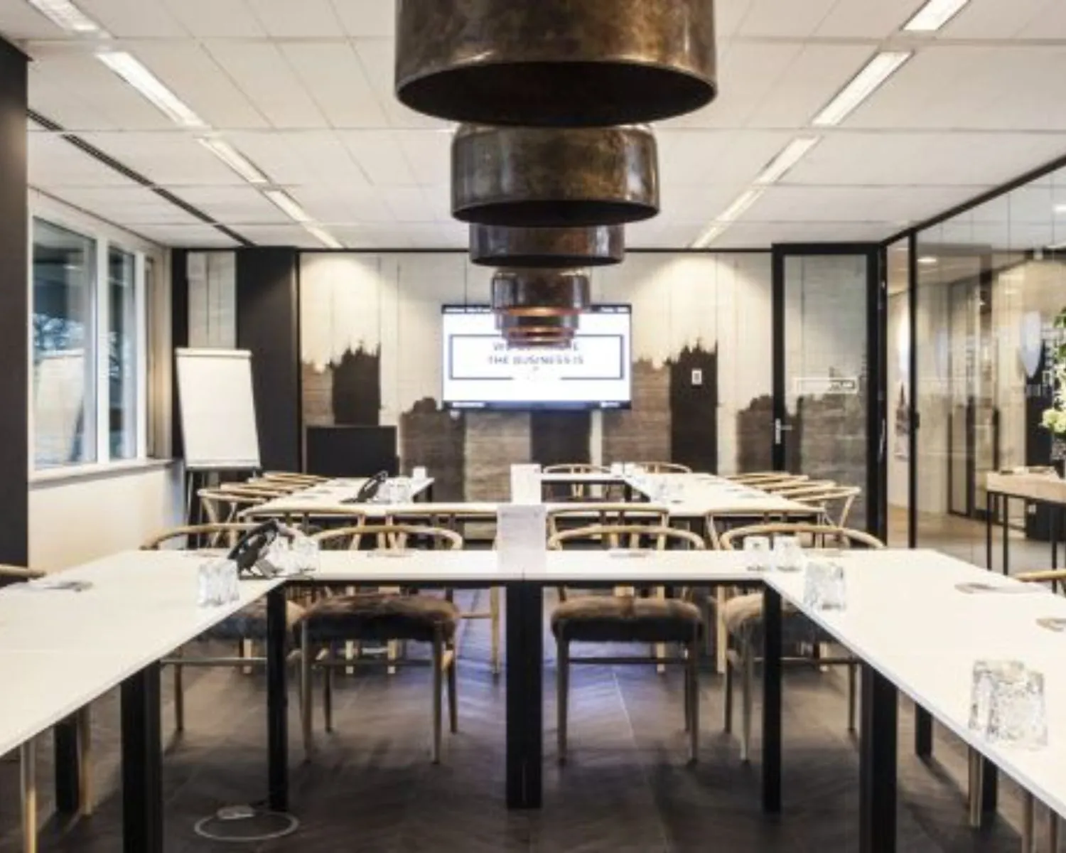 Moderne vergaderruimte met glazen wanden en presentatiescherm aan de Thomas R. Malthuslaan 1 in Amsterdam.