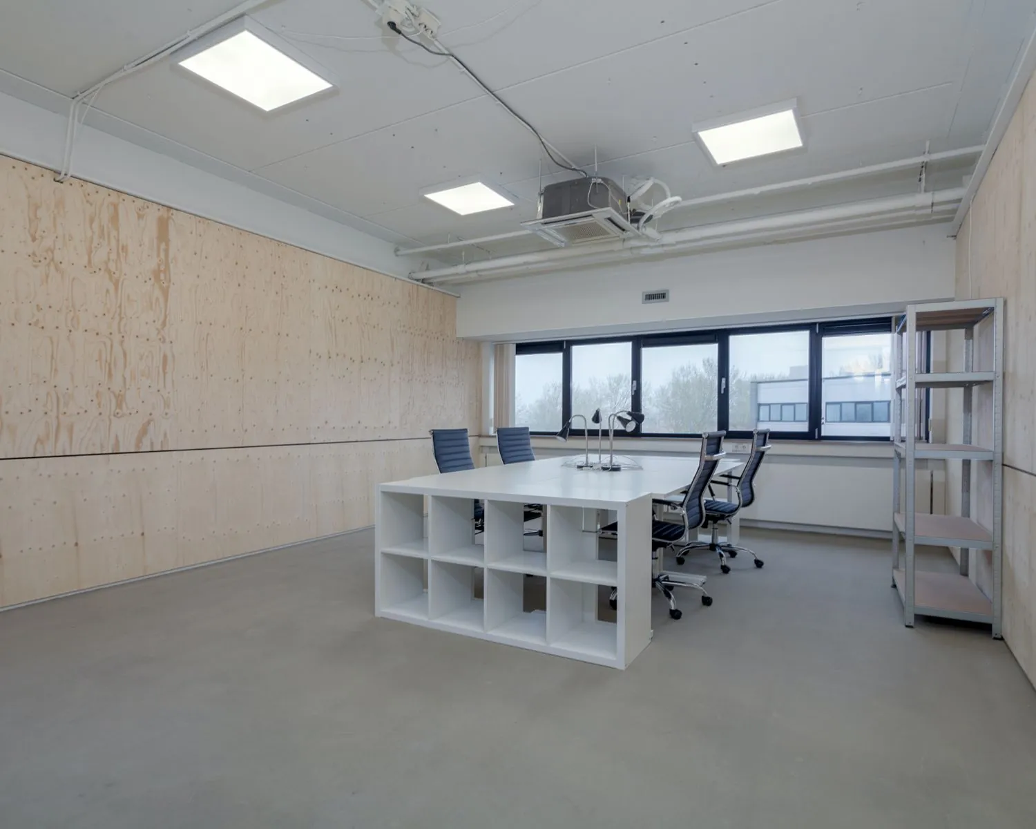 Moderne kantoorruimte met vergadertafel, bureaustoelen en open stellingkast aan de Transistorstraat 151 in Almere.