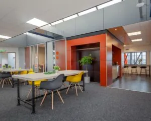 Moderne kantoorruimte aan de Transistorstraat 151 in Almere met kleurrijk meubilair, open werkplekken en een gezamenlijke keuken.