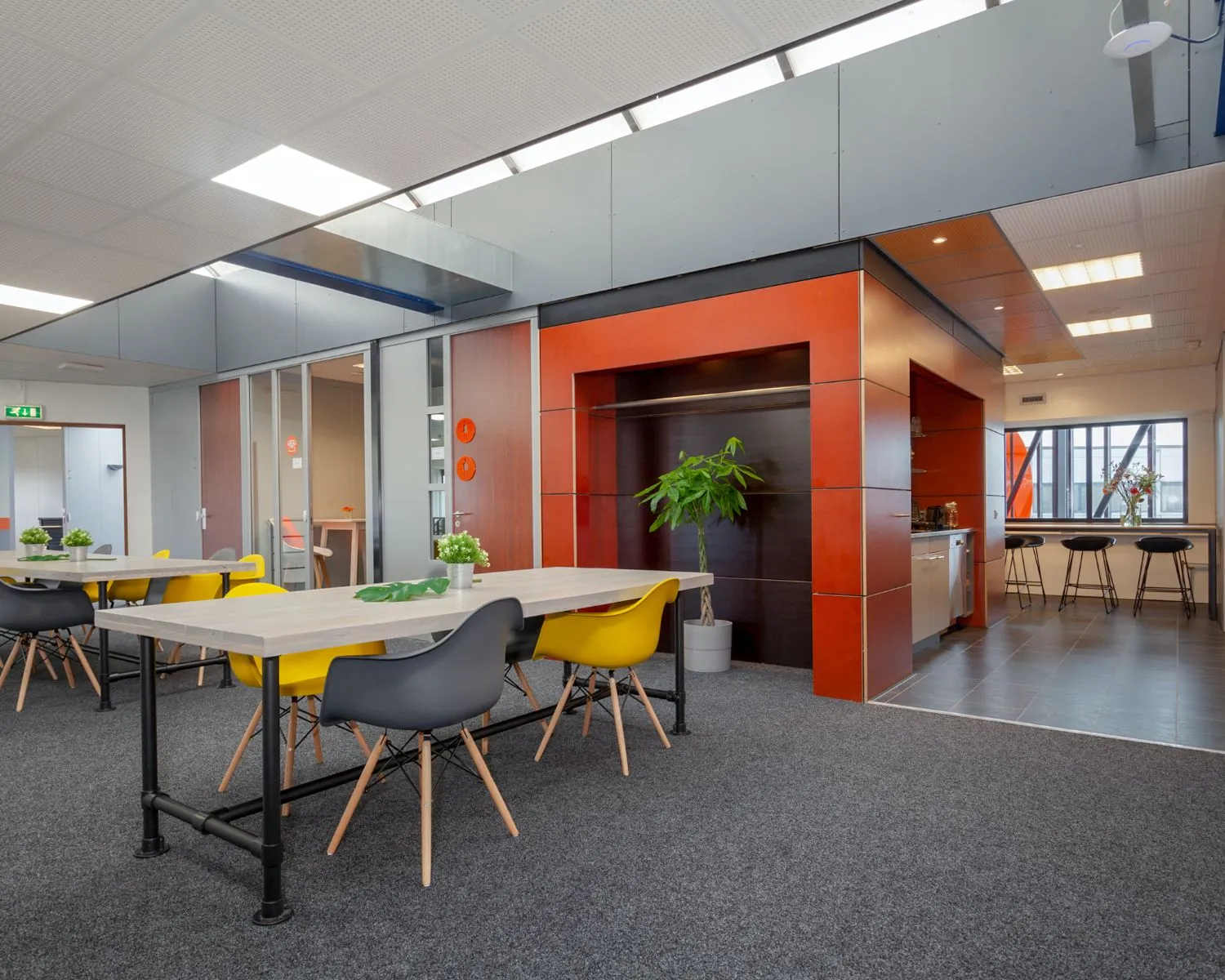 Moderne kantoorruimte aan de Transistorstraat 151 in Almere met kleurrijk meubilair, open werkplekken en een gezamenlijke keuken.