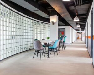 Moderne kantoorruimte aan de Turfstekerstraat 63 in Aalsmeer met glazen wand, kleurrijke stoelen en een strakke afwerking.