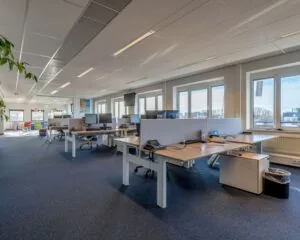 Moderne en ruime kantoorruimte met werkplekken en grote ramen aan de Vossenstraat 6-5.
