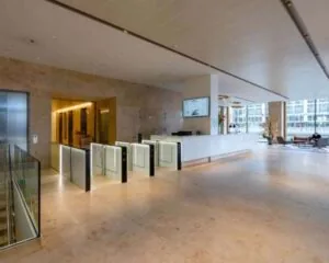 Moderne ontvangsthal van kantoorgebouw Weena 778 met receptiebalie, toegangspoortjes en wachtruimte.