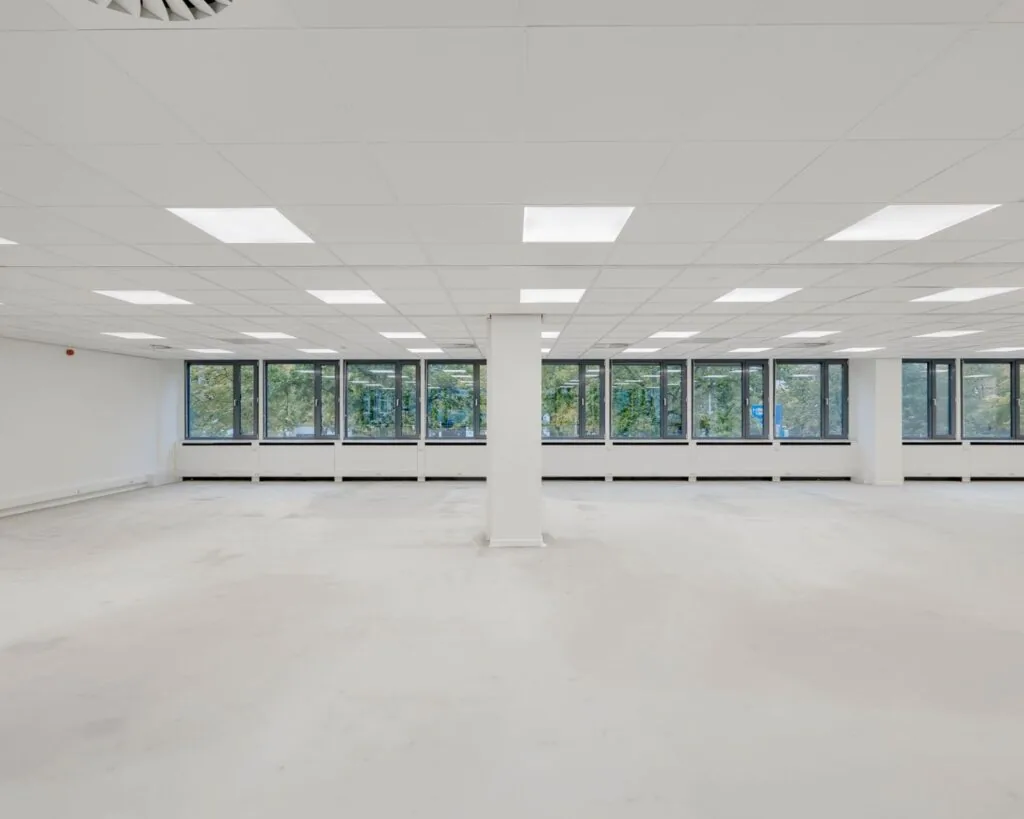 Lichte, lege kantoorruimte met systeemplafond en grote ramen aan de Westblaak 107-147.