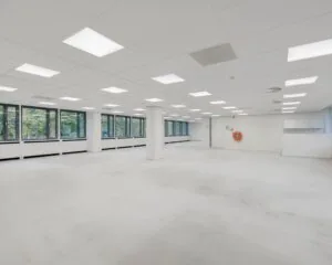 Lichte, open kantoorruimte te huur aan de Westblaak met grote ramen en systeemplafondverlichting.