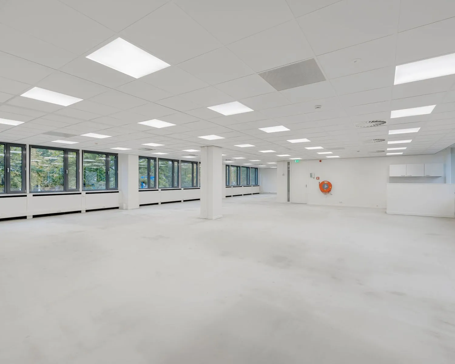 Lichte, open kantoorruimte te huur aan de Westblaak met grote ramen en systeemplafondverlichting.