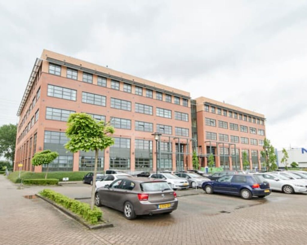 Modern kantoorgebouw aan de Zonnebaan 8 in Utrecht met ruime parkeergelegenheid op de voorgrond.