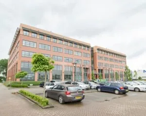 Modern kantoorgebouw aan de Zonnebaan 8 in Utrecht met ruime parkeergelegenheid op de voorgrond.