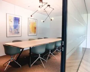 Moderne vergaderruimte met lange tafel, designstoelen en kunst aan de muur in kantoorruimte aan de Entree 230-260 in Amsterdam.