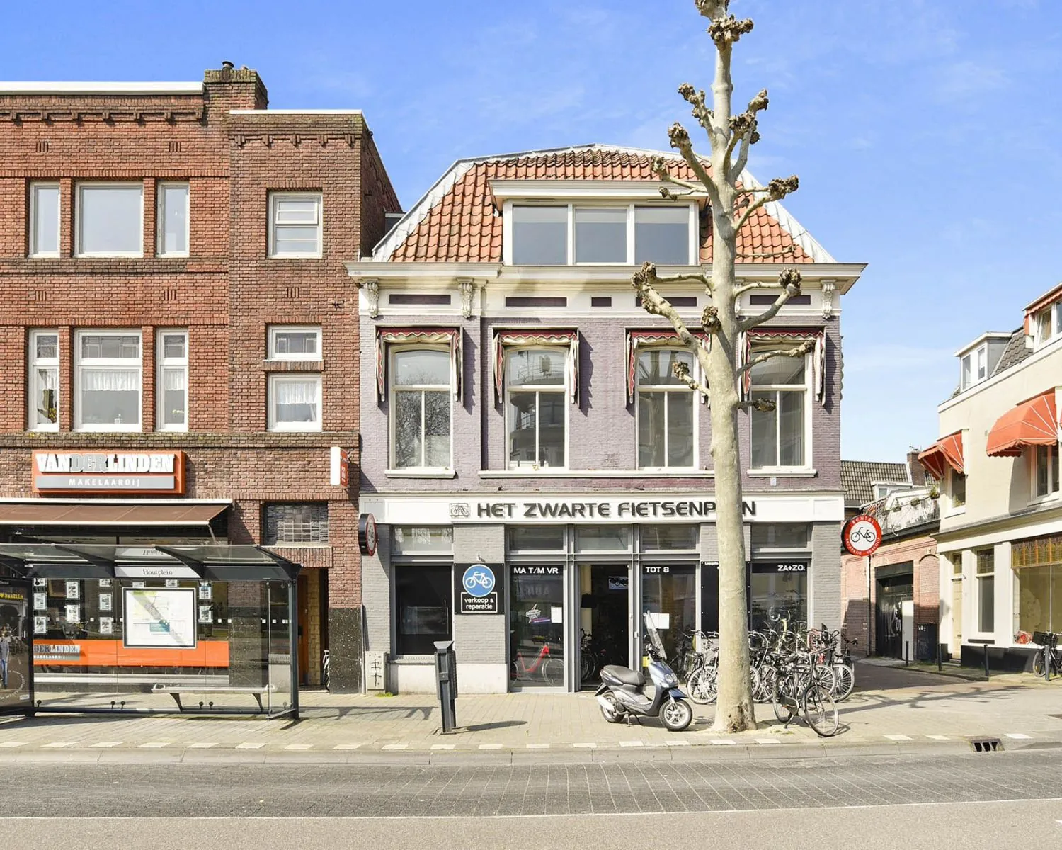 Voorgevel van een karakteristiek pand aan het Houtplein 22 in Haarlem met fietsenwinkel Het Zwarte Fietsenplan op de begane grond.