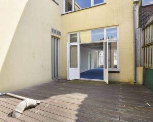 Houten terras met openstaande deuren naar een kantoorruimte aan het Houtplein 22 in Haarlem.