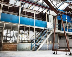 Industriële kantoorruimte te huur aan het Kalkhovenplein 3b in Halfweg met een metalen trap en grote ramen.