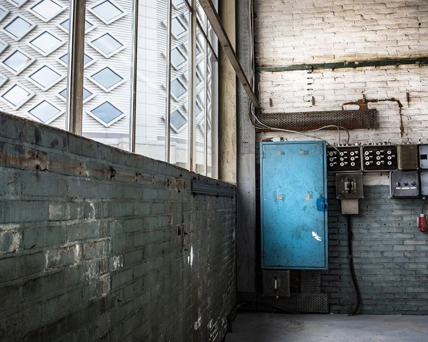 Industriële kantoorruimte met betonnen vloer, oude meterkasten en grote ramen aan het Kalkhovenplein 3b in Halfweg.