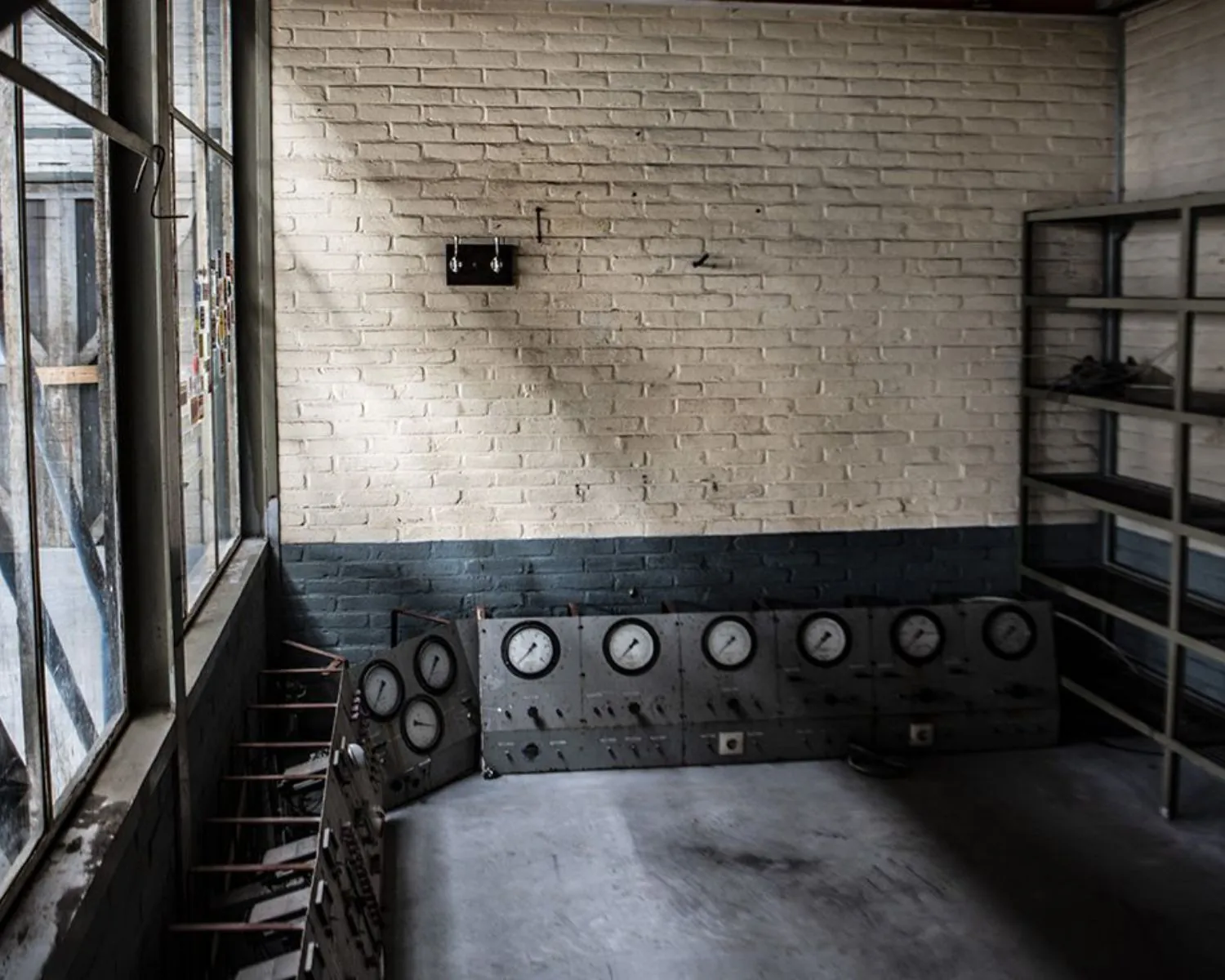 Lege industriële kantoorruimte met oude bedieningspanelen en metalen stellingkasten aan het Kalkhovenplein 3b in Halfweg.