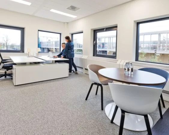 Moderne kantoorruimte in Kennemerhaghe aan de Leidsevaartweg 99 in Heemstede met werkplekken, vergadertafel en grote ramen.