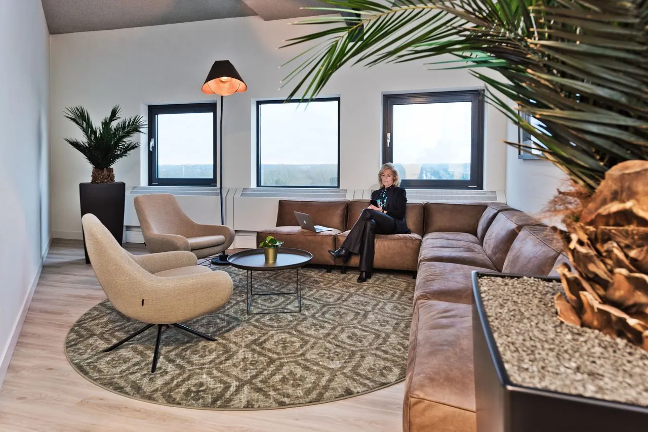 Moderne kantoorlounge in Kennemerhaghe met zithoek, designmeubilair en grote ramen in Heemstede.