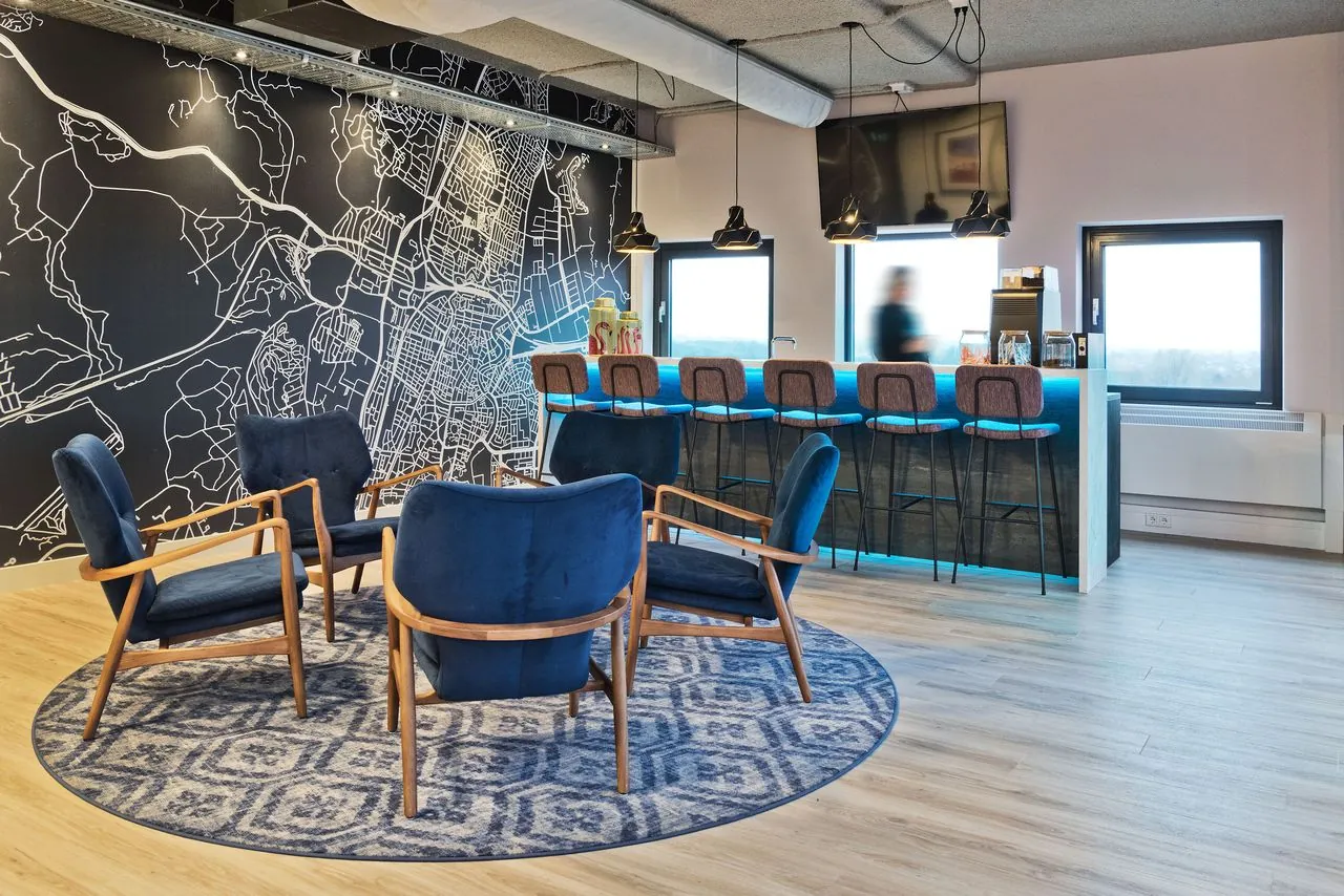 Moderne kantoorruimte met zithoek, bar en een muurdecoratie van een stadsplattegrond in Kennemerhaghe, Heemstede.