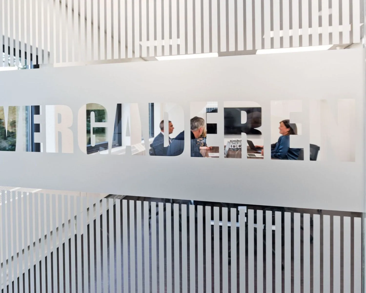 Mensen in overleg in een vergaderruimte van het kantoorpand Kennemerhaghe aan de Leidsevaartweg 99 in Heemstede.