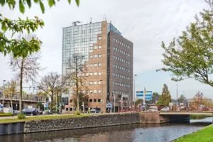 Kantoorgebouw Kennemerhaghe aan de Leidsevaartweg 99 in Heemstede, gelegen aan het water met omliggende infrastructuur en groen.