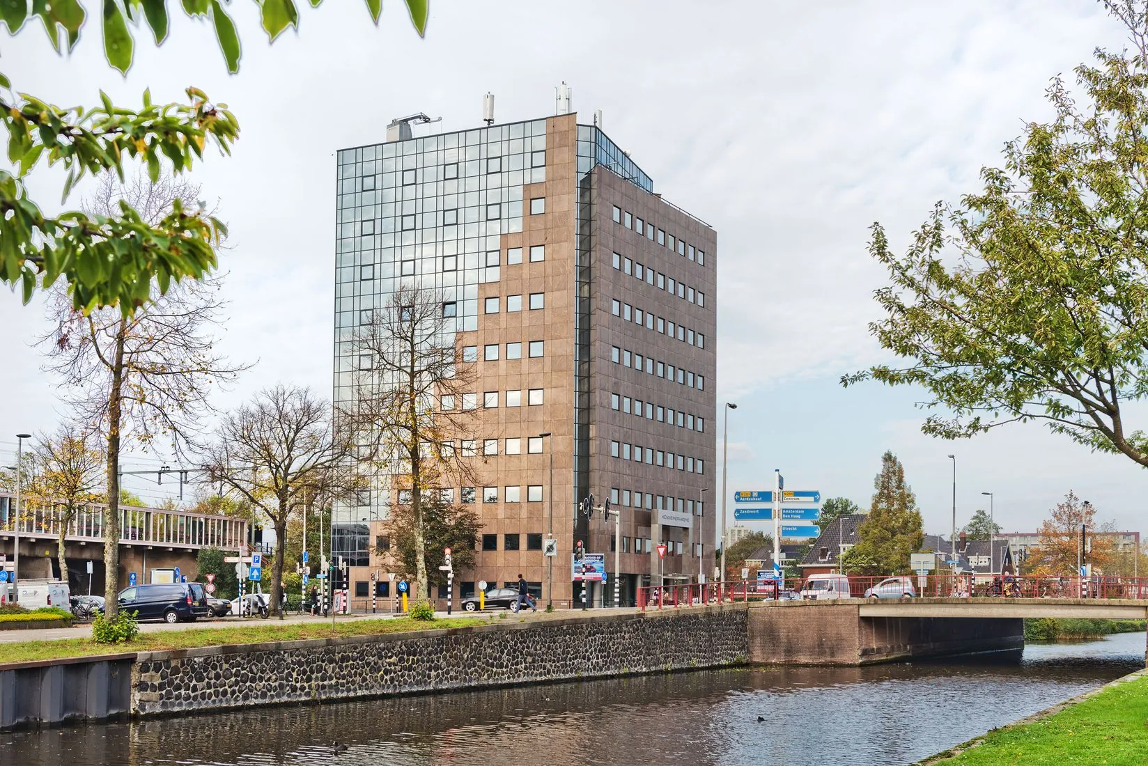 Kantoorgebouw Kennemerhaghe aan de Leidsevaartweg 99 in Heemstede, gelegen aan het water met omliggende infrastructuur en groen.