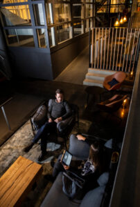 Twee mensen zitten in een moderne loungehoek van een kantoorruimte aan het Kennemerplein in Haarlem.