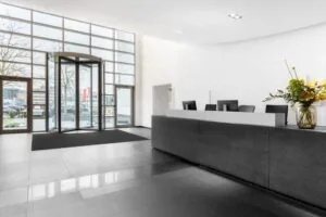 Moderne en lichte entreehal van een kantoorpand aan de Laarderhoogtweg in Amsterdam met receptiebalie en draaideur.