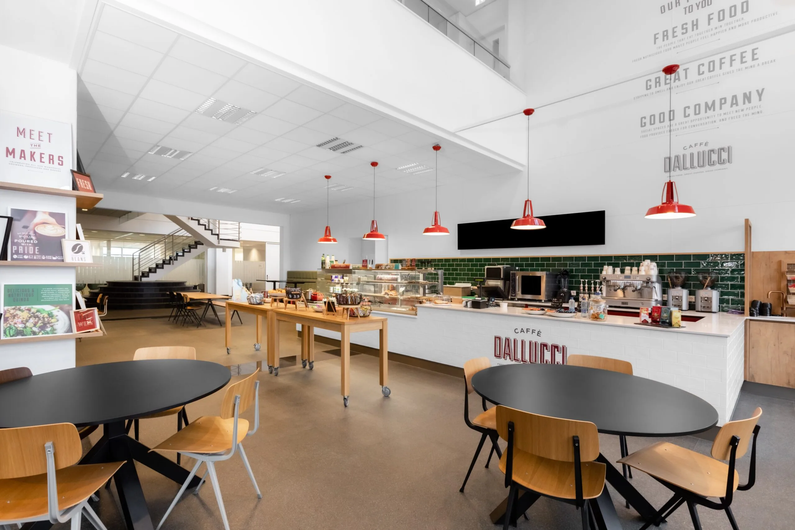 Moderne koffiebar en lunchruimte in een kantoor aan de Laarderhoogtweg in Amsterdam met zitplaatsen en een open balie.