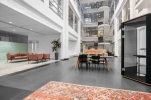 Moderne open kantoorruimte aan de Laarderhoogtweg in Amsterdam met zithoeken, vergadertafel en meerdere verdiepingen.