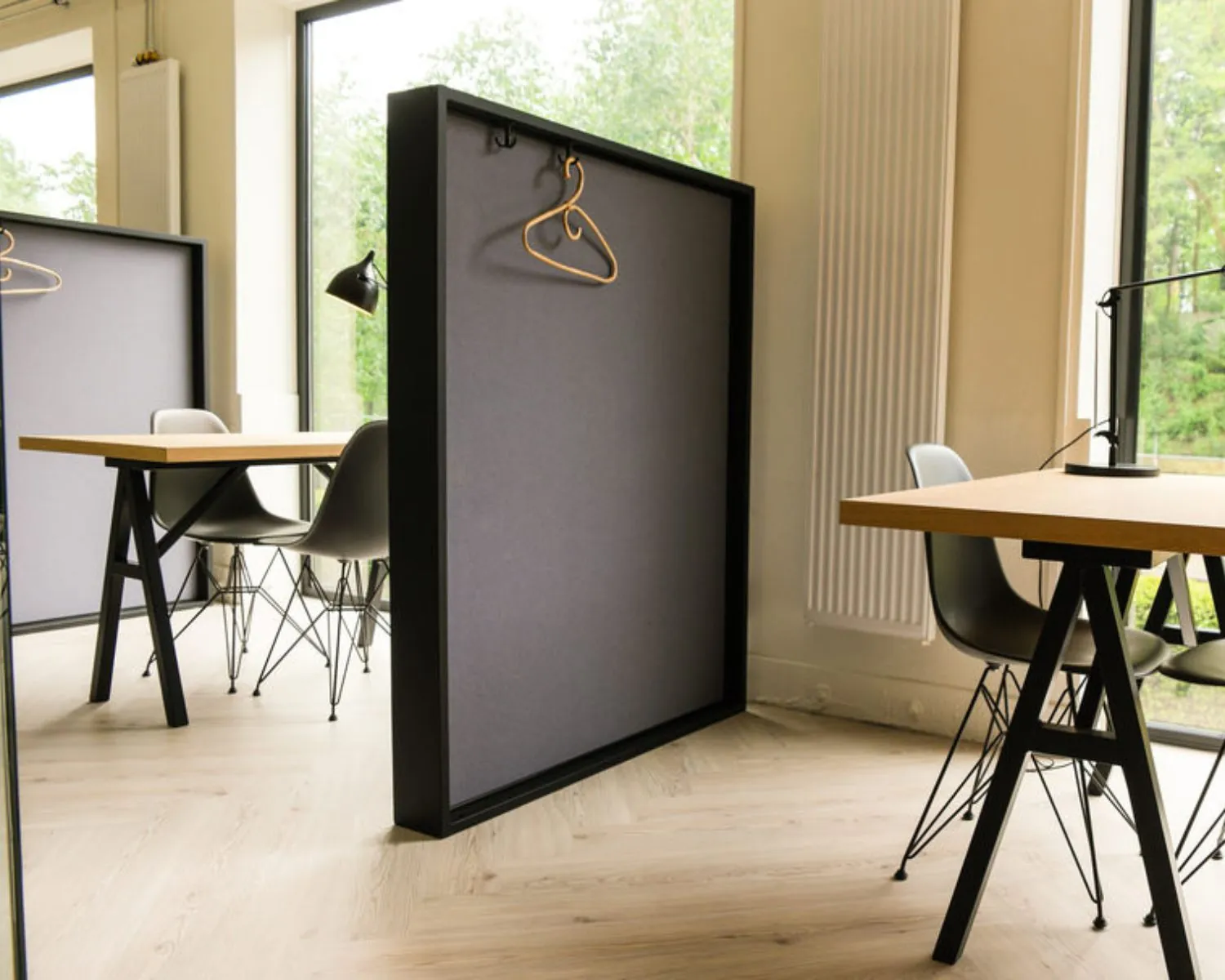 Moderne kantoorruimte aan de Marten Meesweg in Rotterdam met houten bureaus, scheidingswanden en grote ramen met uitzicht op groen.