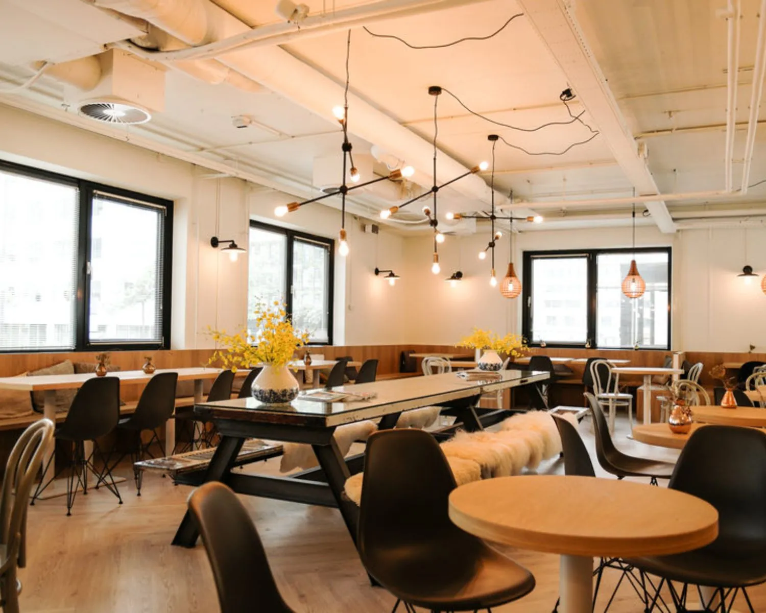 Moderne en sfeervol ingerichte kantoorruimte met zithoeken, grote ramen en industriële plafondlampen aan de Marten Meesweg 8-10 in Rotterdam.