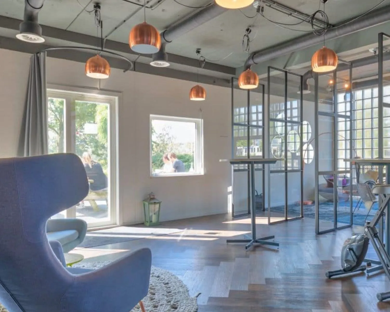 Moderne kantoorruimte aan de Overschiestraat 65 in Amsterdam met grote ramen, glazen scheidingswanden en designmeubilair.