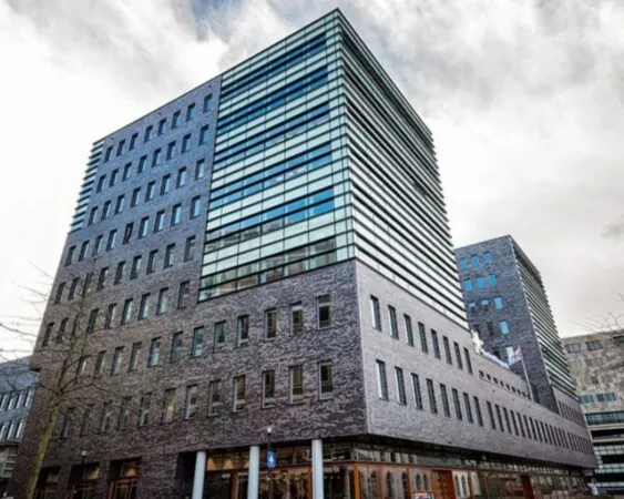 Modern kantoorgebouw aan het Smallepad 32 in Amersfoort met grote glazen gevel en bakstenen buitenkant.