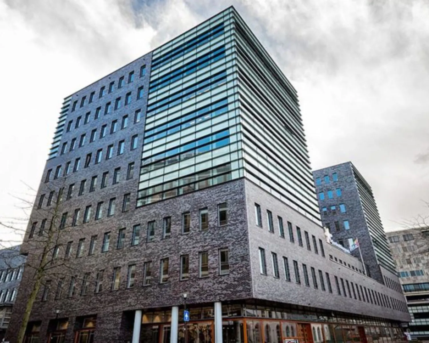 Modern kantoorgebouw aan het Smallepad 32 in Amersfoort met grote glazen gevel en bakstenen buitenkant.