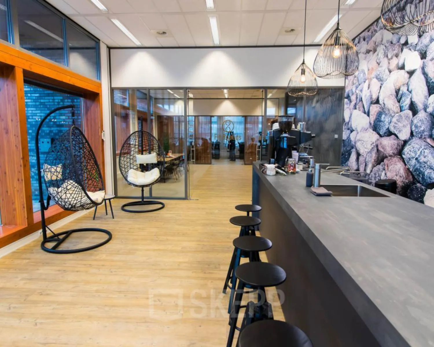 Moderne kantoorruimte aan het Smallepad 32 in Amersfoort met koffiebar, hangstoelen en glazen vergaderruimtes.